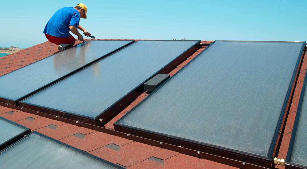 zonneboiler installateur installeert vlakke plaat zonnecollector